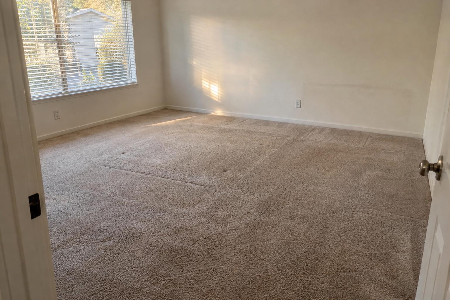 Empty bedroom with carpet marks where a bed frame and dresser stood